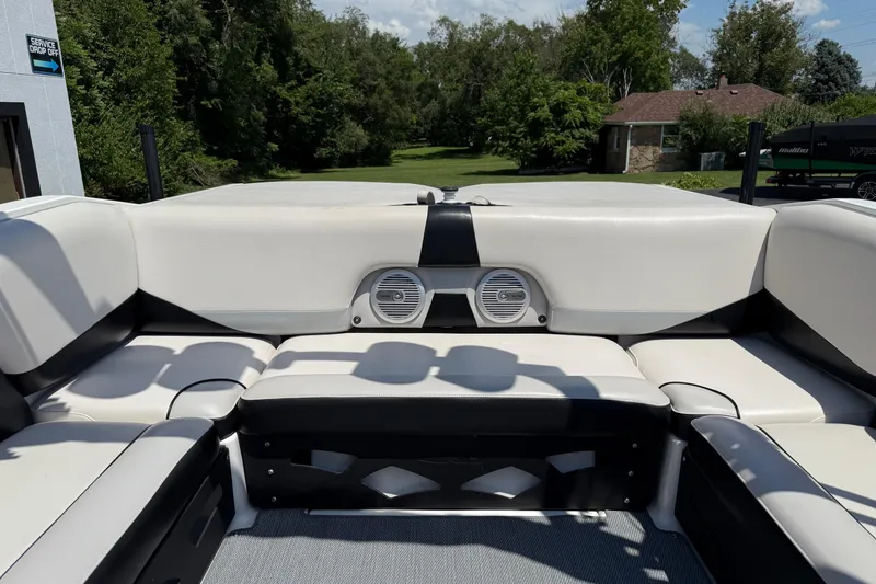 Slide: The Image of 2014 Axis A22 boat interior with white and black seating, outdoor setting. - 33