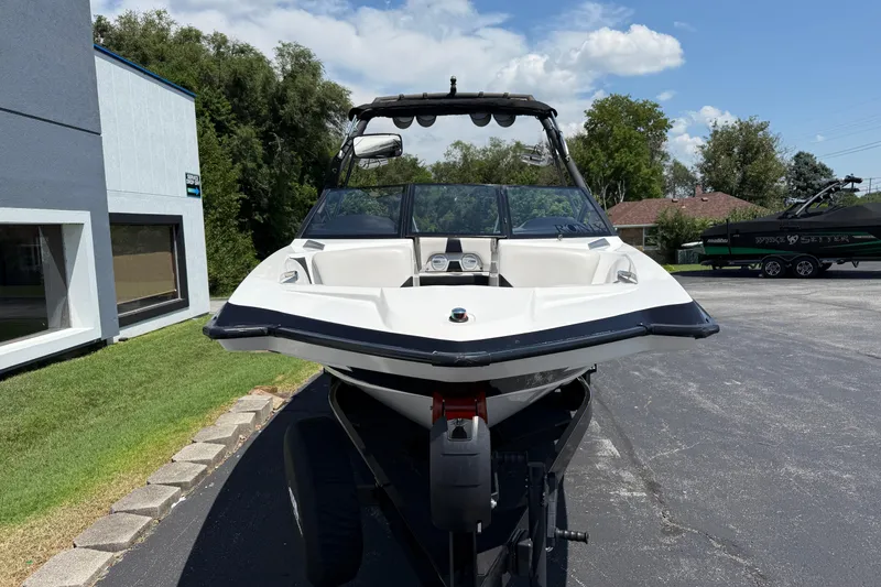 Slide: The Image of 2014 Axis A22 boat on trailer, parked outdoors near a building. - 5