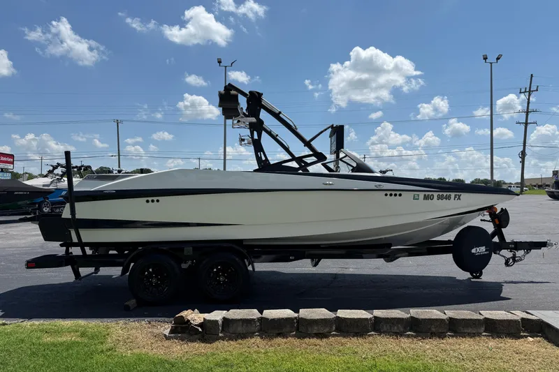 Slide: The Image of 2014 Axis A22 boat on trailer under a clear blue sky. - 8