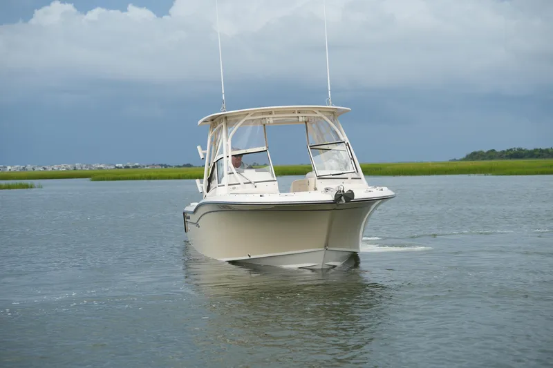 Slide: The Image of 2018 Grady-White Freedom 235 boat cruising on calm waters under cloudy skies. - 11