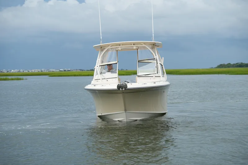 Slide: The Image of 2018 Grady-White Freedom 235 boat cruising on calm waters under a cloudy sky. - 12