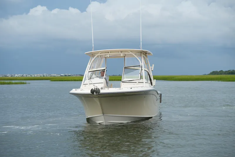 Slide: The Image of 2018 Grady-White Freedom 235 boat cruising on calm waters under cloudy skies. - 13