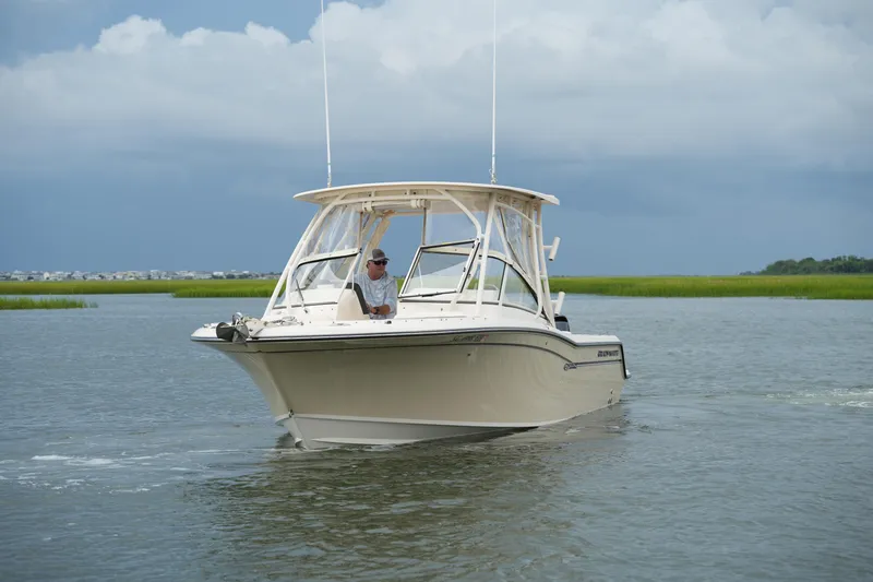 Slide: The Image of 2018 Grady-White Freedom 235 boat cruising on calm waters under cloudy skies. - 14