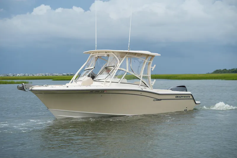 Slide: The Image of 2018 Grady-White Freedom 235 boat cruising on calm waters under a cloudy sky. - 16