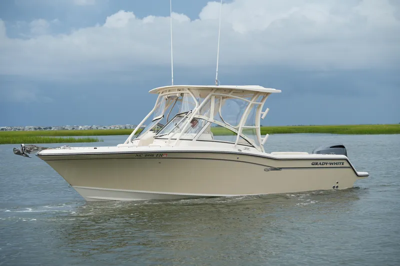 Slide: The Image of 2018 Grady-White Freedom 235 boat cruising on calm waters under cloudy skies. - 17