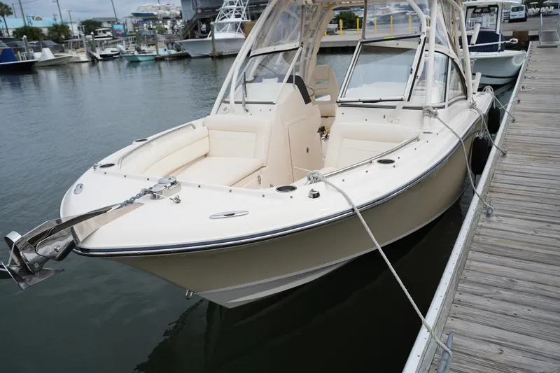 Slide: The Image of 2018 Grady-White Freedom 235 boat docked at marina, featuring sleek design and spacious seating. - 18
