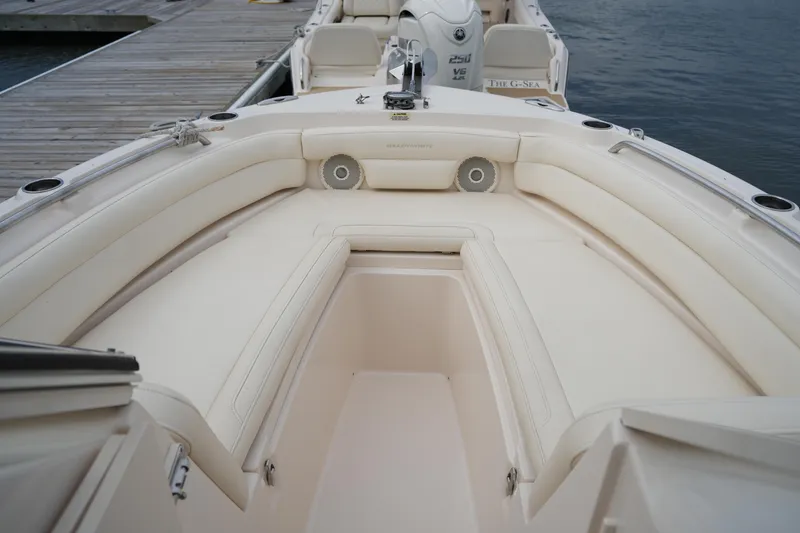 Slide: The Image of 2018 Grady-White Freedom 235 boat interior with cushioned seating and dock view. - 20