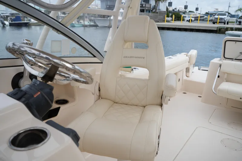 Slide: The Image of 2018 Grady-White Freedom 235 boat interior with steering wheel and cushioned seating. - 31
