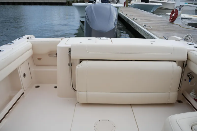 Slide: The Image of 2018 Grady-White Freedom 235 boat interior with seating and dock view. - 35