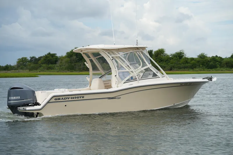 Slide: The Image of 2018 Grady-White Freedom 235 boat cruising on a calm lake with lush greenery. - 6