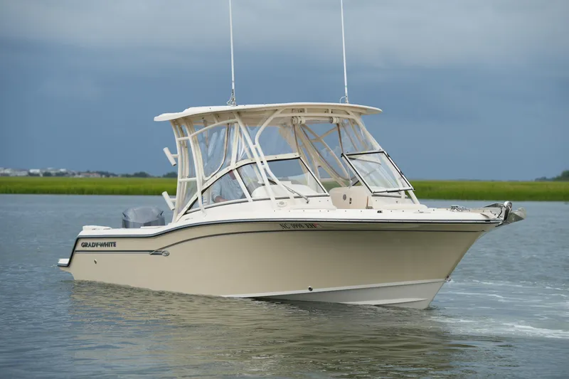 Slide: The Image of 2018 Grady-White Freedom 235 boat cruising on calm waters under a cloudy sky. - 8