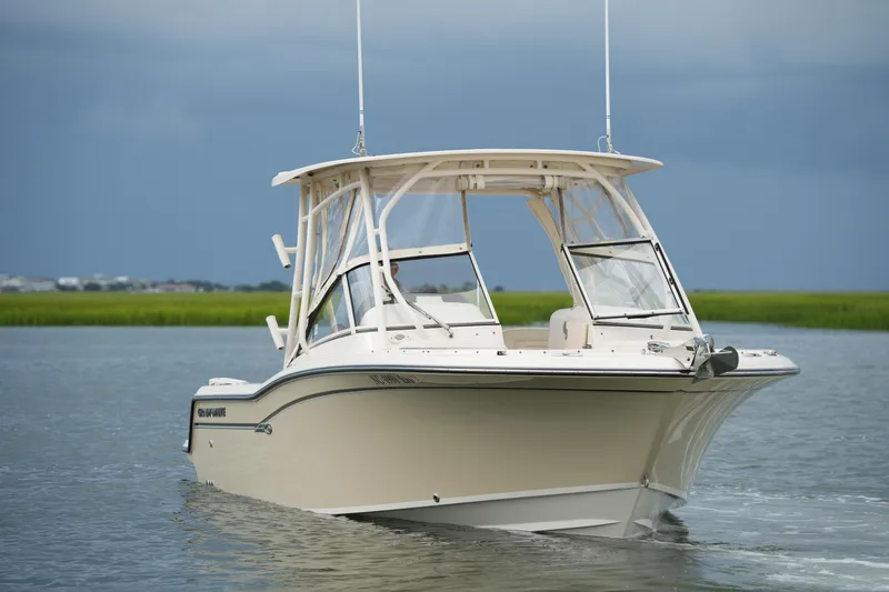 Slide: The Image of 2018 Grady-White Freedom 235 boat cruising on calm water under cloudy skies. - 9