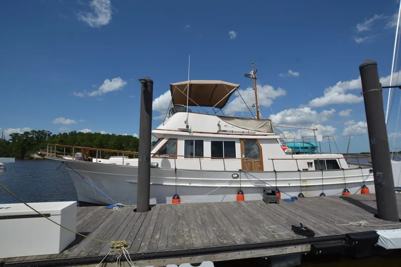 Slide: The Image of 1985 Albin 43 Trawler docked at marina under blue sky with clouds. - 1
