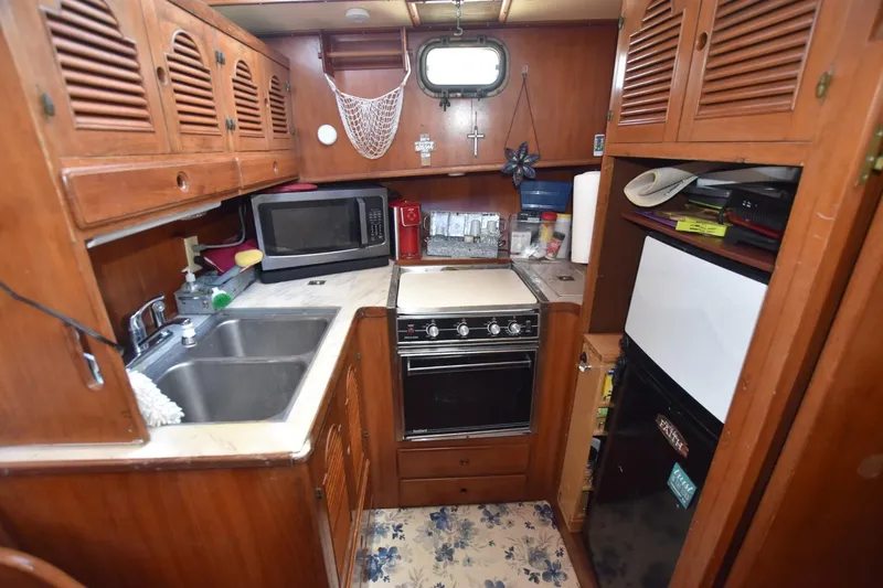 Slide: The Image of Cozy bedroom interior of 1985 Albin 43 Trawler with striped bedding and wooden accents. - 15