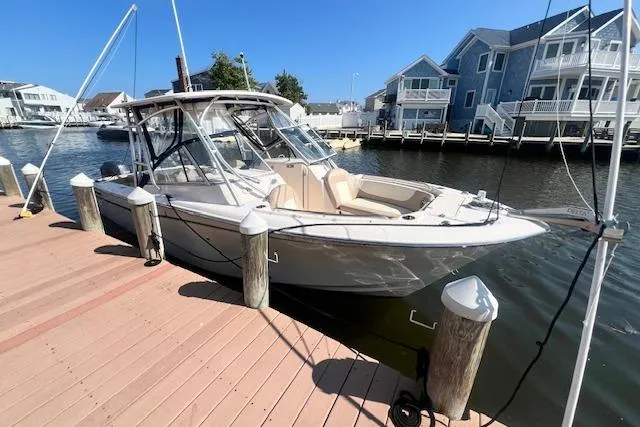 Slide: The Image of 2013 Grady-White Freedom 275 boat docked by waterfront homes. - 0