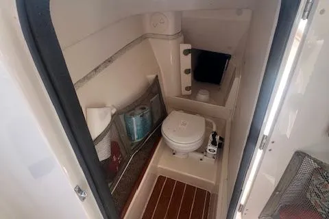 Slide: The Image of 2013 Grady-White Freedom 275 boat interior bathroom with toilet and storage. - 17