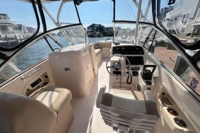 Slide: The Image of 2013 Grady-White Freedom 275 boat interior with helm, seating, and waterfront view. - 2