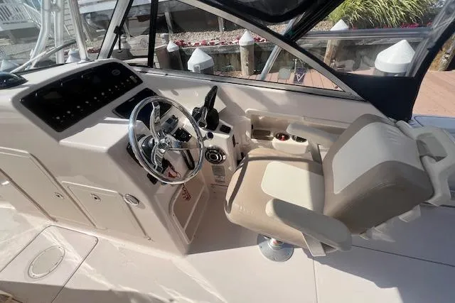 Slide: The Image of 2013 Grady-White Freedom 275 boat cockpit with steering wheel and captain's chair. - 3