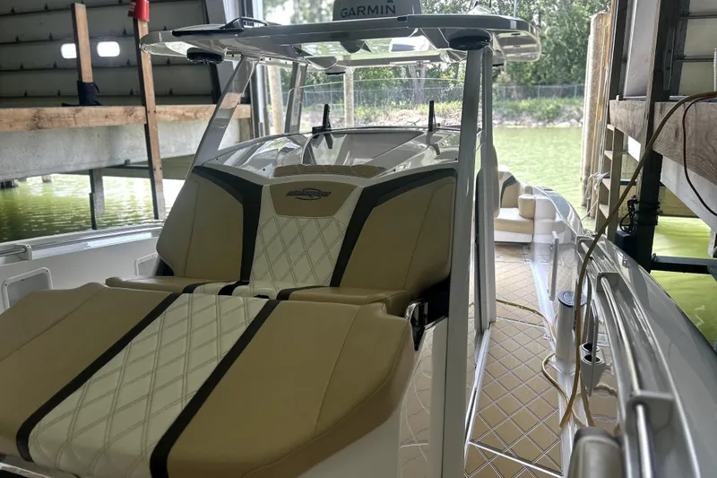 Slide: The Image of 2019 Sunsation 34 CCX boat interior with beige and black seating, diamond-patterned flooring. - 14