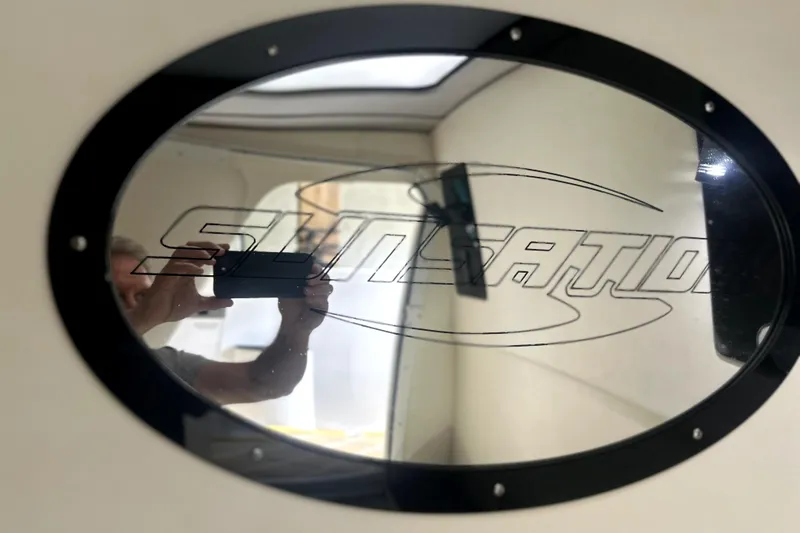 Slide: The Image of 2019 Sunsation 34 CCX cabin interior with beige seating, kitchenette, and modern amenities. - 24