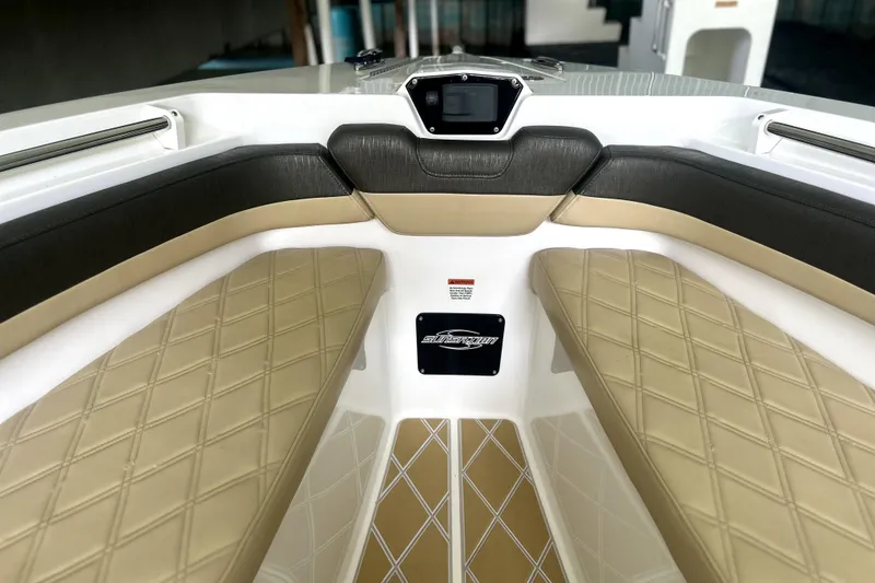Slide: The Image of 2019 Sunsation 34 CCX boat hull displayed indoors with dealership sign. - 3