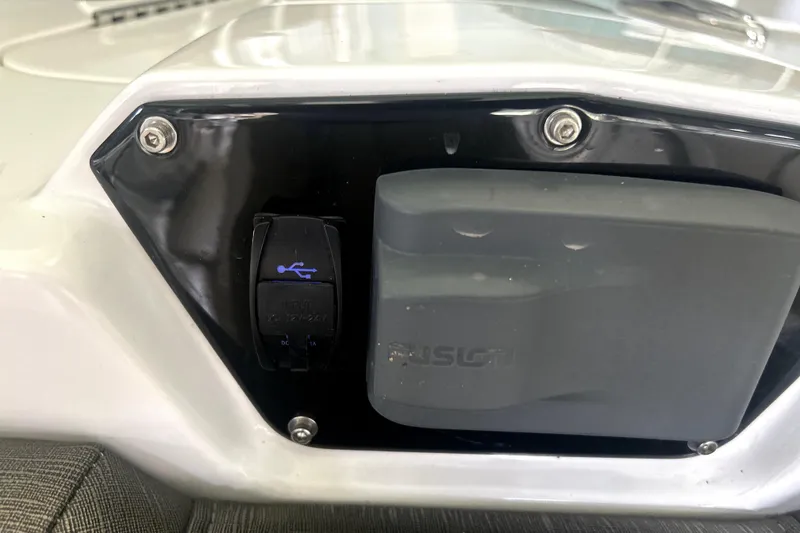 Slide: The Image of 2019 Sunsation 34 CCX boat docked in a covered marina with a jet ski nearby. - 6