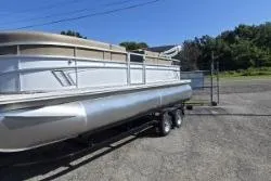 Slide: The Image of 2025 SunChaser Vista 22 Fish pontoon boat on trailer, parked outdoors. - 11