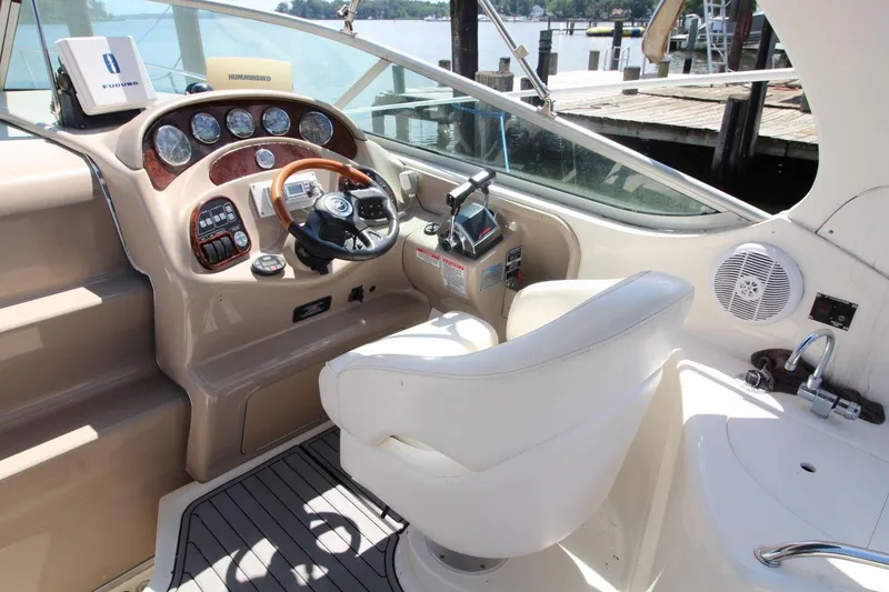 Slide: The Image of 2005 Sea Ray 280 Sundancer helm with steering wheel, controls, and gauges. - 11