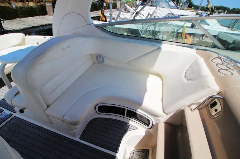 Slide: The Image of 2005 Sea Ray 280 Sundancer boat interior with white seating and deck view. - 12