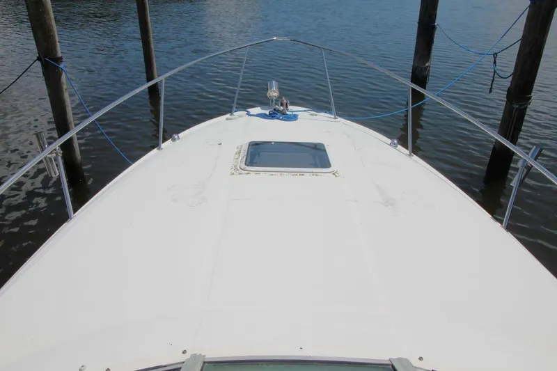 Slide: The Image of 2005 Sea Ray 280 Sundancer boat deck, docked on calm water. - 13