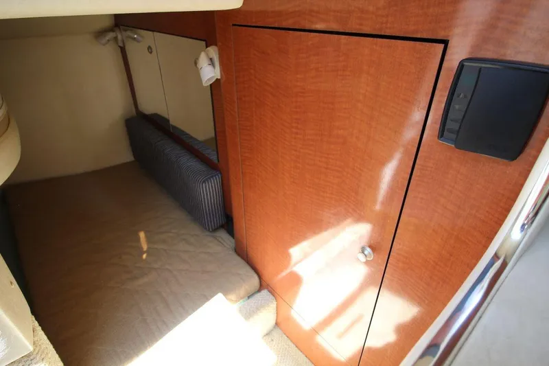 Slide: The Image of 2005 Sea Ray 280 Sundancer cabin interior with wood paneling and cozy sleeping area. - 17