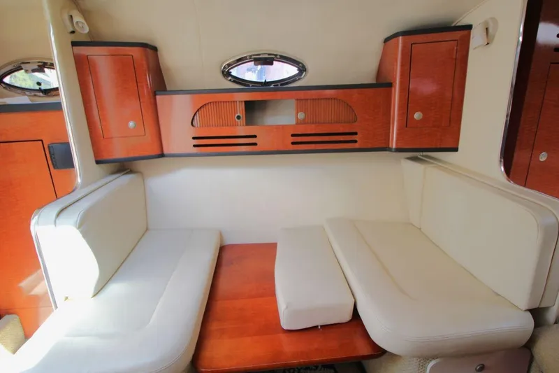 Slide: The Image of Interior of 2005 Sea Ray 280 Sundancer with beige seating and wooden cabinetry. - 18