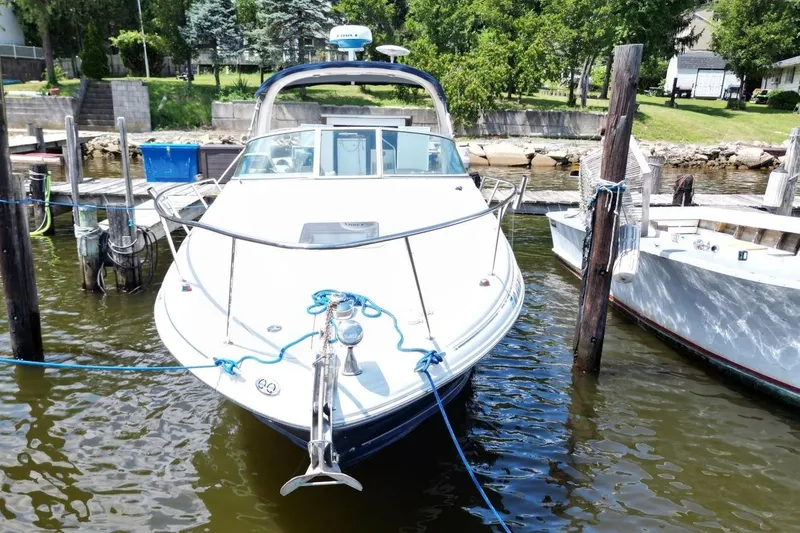 Slide: The Image of 2005 Sea Ray 280 Sundancer docked at a marina, surrounded by calm waters. - 3