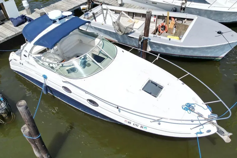 Slide: The Image of 2005 Sea Ray 280 Sundancer docked, featuring a blue canopy and sleek white design. - 4