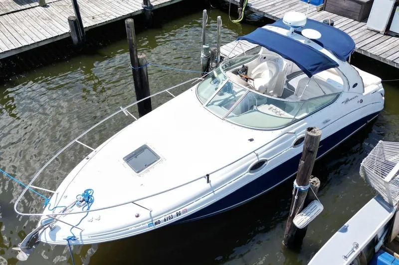 Slide: The Image of 2005 Sea Ray 280 Sundancer docked at marina, featuring sleek design and blue canopy. - 5