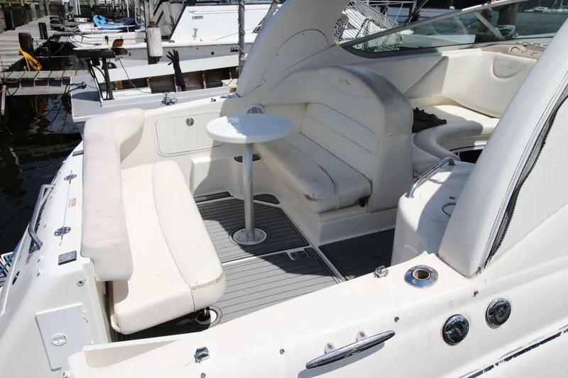 Slide: The Image of 2005 Sea Ray 280 Sundancer boat interior with white seating and table at marina. - 9
