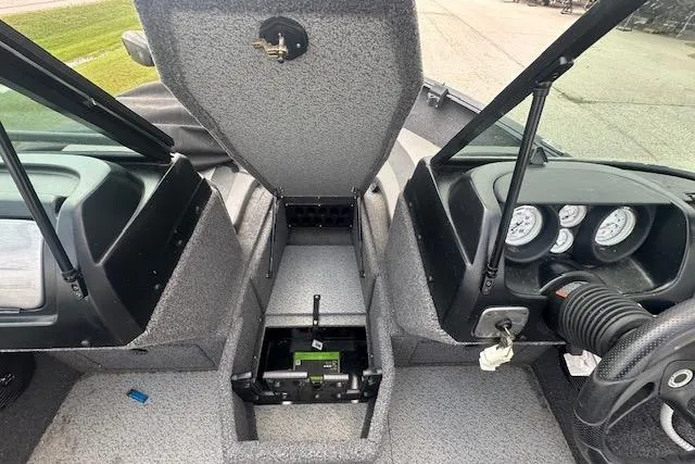 Slide: The Image of 2020 Lund 1775 Adventure Sport boat interior with open storage compartment and dashboard gauges. - 4