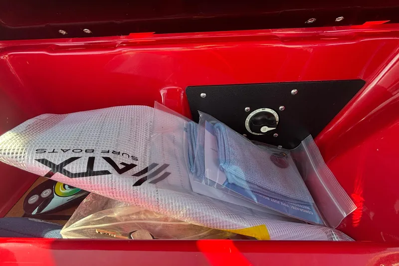 Slide: The Image of Storage compartment of 2026 ATX Surf Boats 24 Type-S with accessories and control panel. - 13