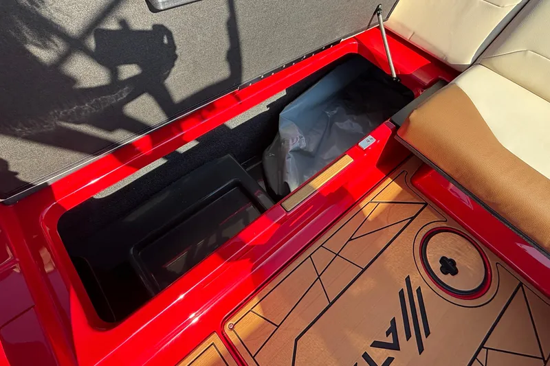 Slide: The Image of 2026 ATX Surf Boats 24 Type-S interior storage compartment with red and tan seating. - 32
