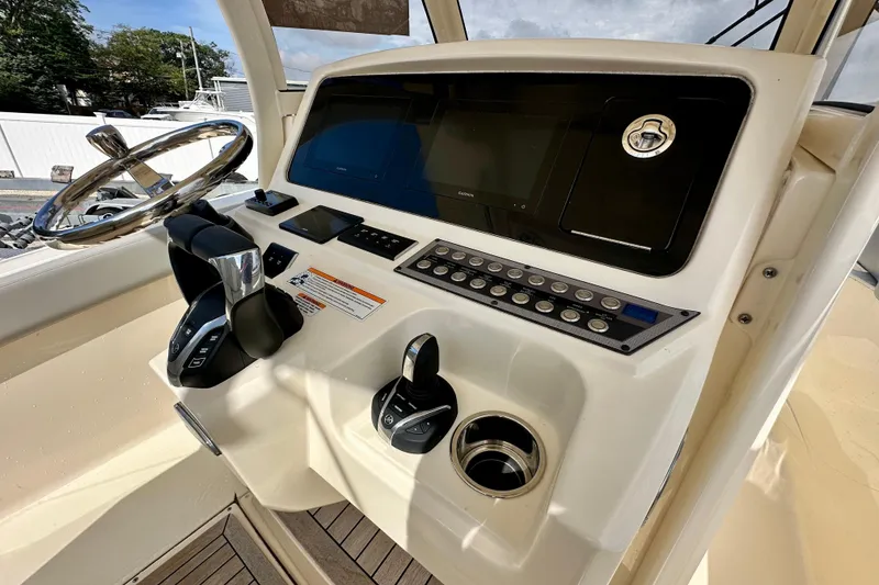 Slide: The Image of 2024 Scout 277 LXF boat dashboard with steering wheel and control panel. - 13