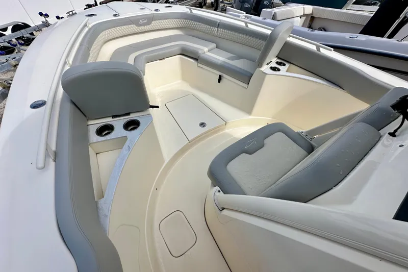 Slide: The Image of 2024 Scout 277 LXF boat interior with gray seating and cup holders. - 19