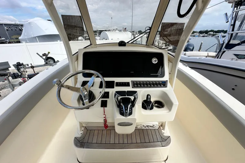 Slide: The Image of 2024 Scout 277 LXF boat helm with steering wheel and control panel. - 23