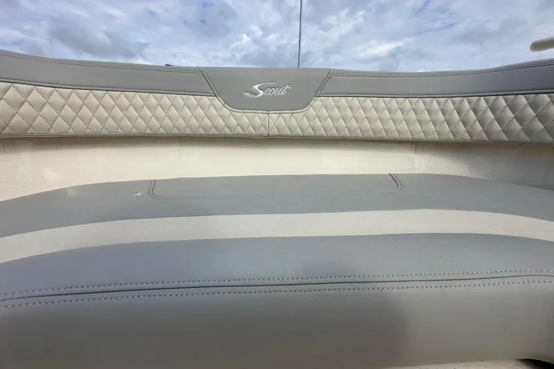 Slide: The Image of 2024 Scout 277 LXF boat interior with quilted gray seating and logo. - 24