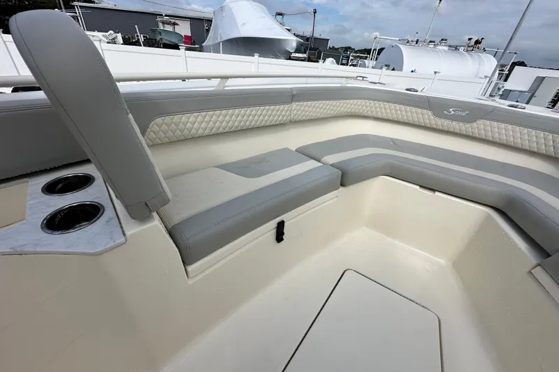 Slide: The Image of 2024 Scout 277 LXF boat interior with cushioned seating and cup holders. - 27