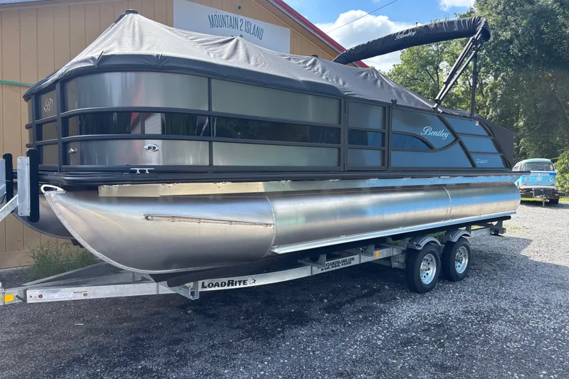 The Image of 2026 Bentley Pontoons Legacy 220 Swingback Dual Captain on trailer, outdoor setting. - 1