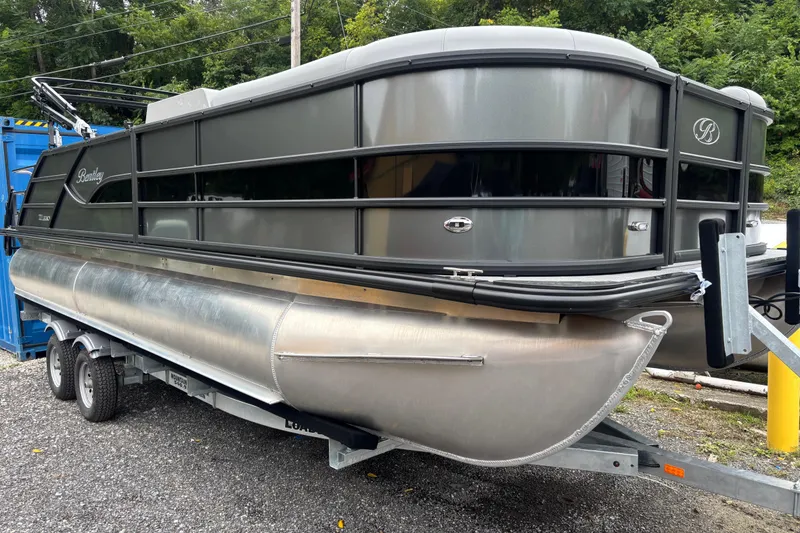 Slide: The Image of 2026 Bentley Pontoons Legacy 220 Swingback Dual Captain on trailer, parked outdoors. - 7