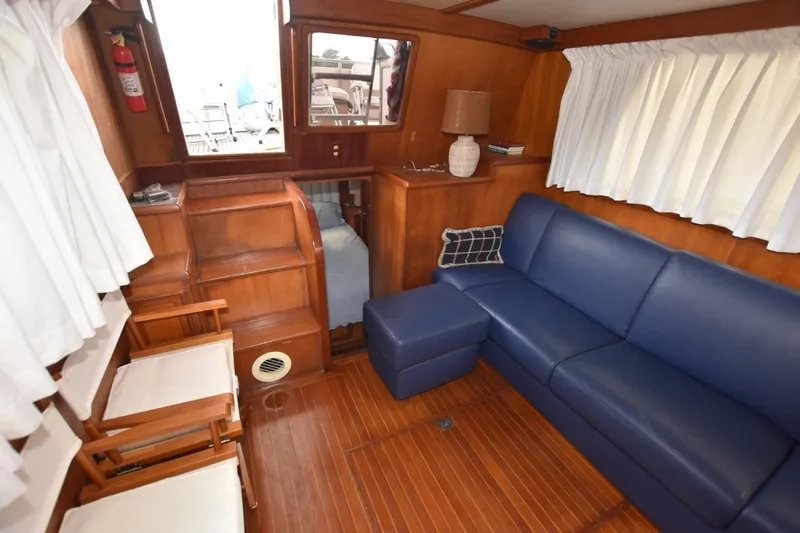 Slide: The Image of Interior of 1987 Hartman-Palmer Offshore 38 Sundeck with blue sofa and wooden accents. - 10