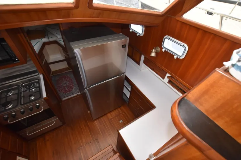 Slide: The Image of 1987 Hartman-Palmer Offshore 38 Sundeck interior with kitchen and wooden cabinetry. - 11