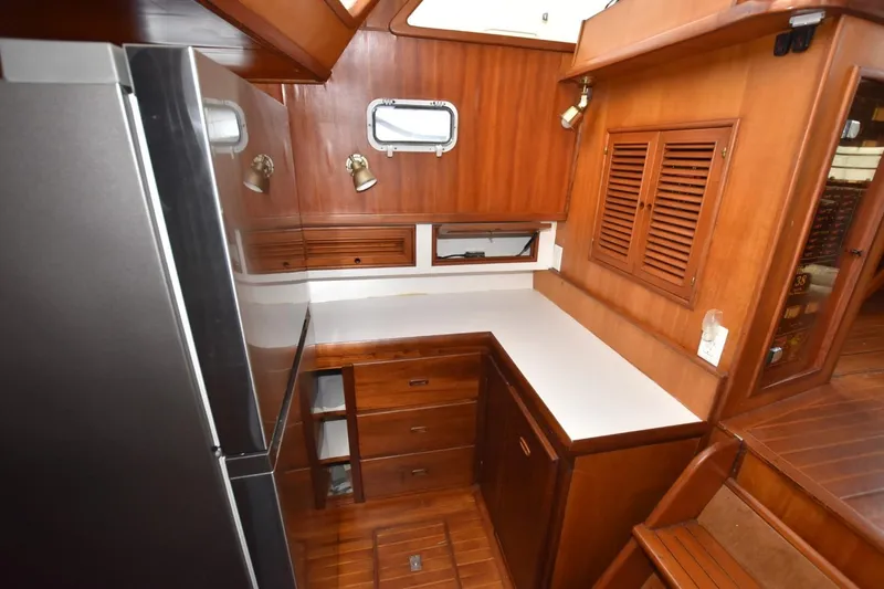 Slide: The Image of 1987 Hartman-Palmer Offshore 38 Sundeck interior with wood cabinetry and compact kitchen area. - 15