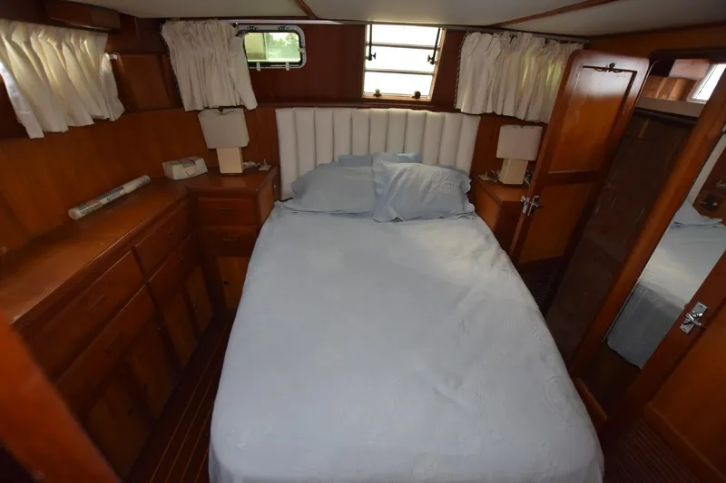 Slide: The Image of 1987 Hartman-Palmer Offshore 38 Sundeck cabin with bed, wooden cabinetry, and windows. - 17